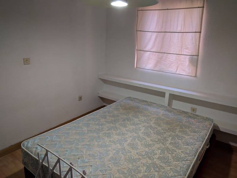 Dormitorio de un piso en alquiler tal como lo encontró Inmperson: colchón sin vestir y habitación vacía