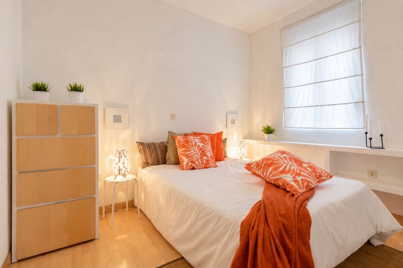El mismo dormitorio preparado por Inmperson para alquilar: cama vestida, cómoda, lámparas y decoración